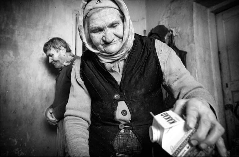 An elderly woman receiving a carton of supplies at her door